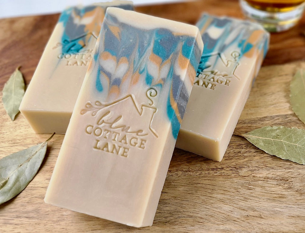 Three bars of soap with a marbled design on a wooden surface, featuring the 'Cottage Lane' brand.