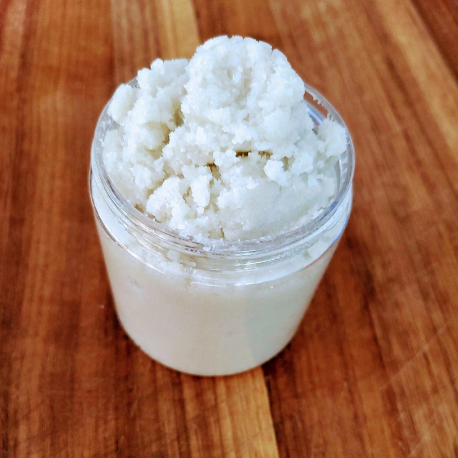 Jar of sugar scrub with extra scrub on top.